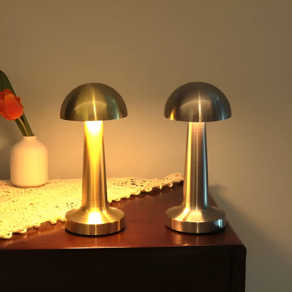 Two metallic table lamps on a wooden surface with a soft background