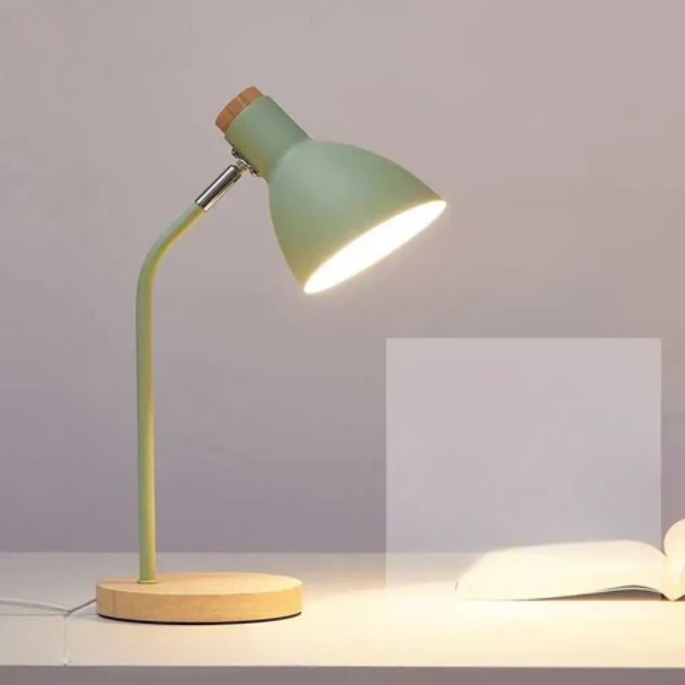 Green desk lamp with wooden base on a neutral background