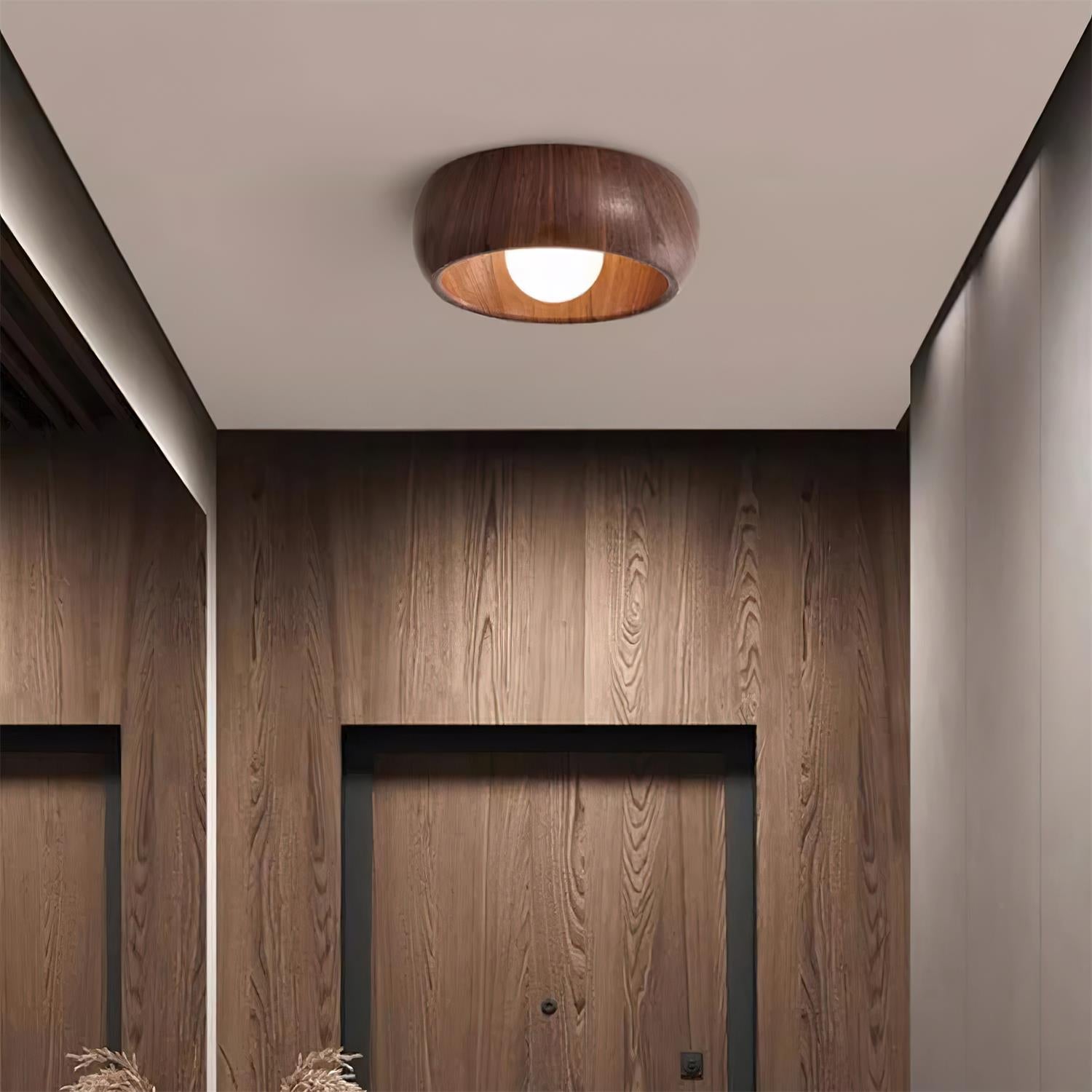 Wooden ceiling light fixture in a room with wooden walls.