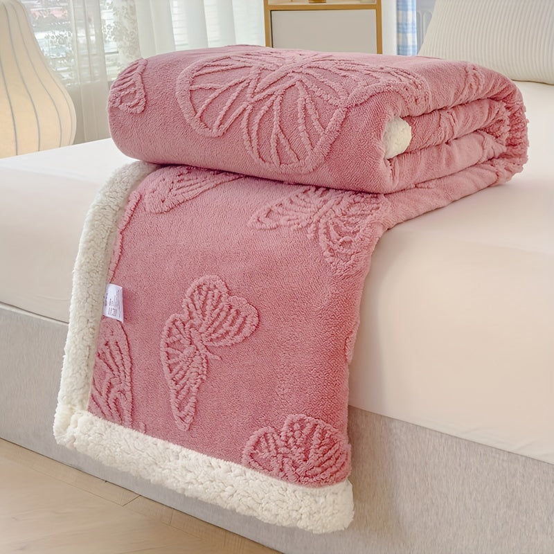 Pink textured blanket with bow design on a white couch