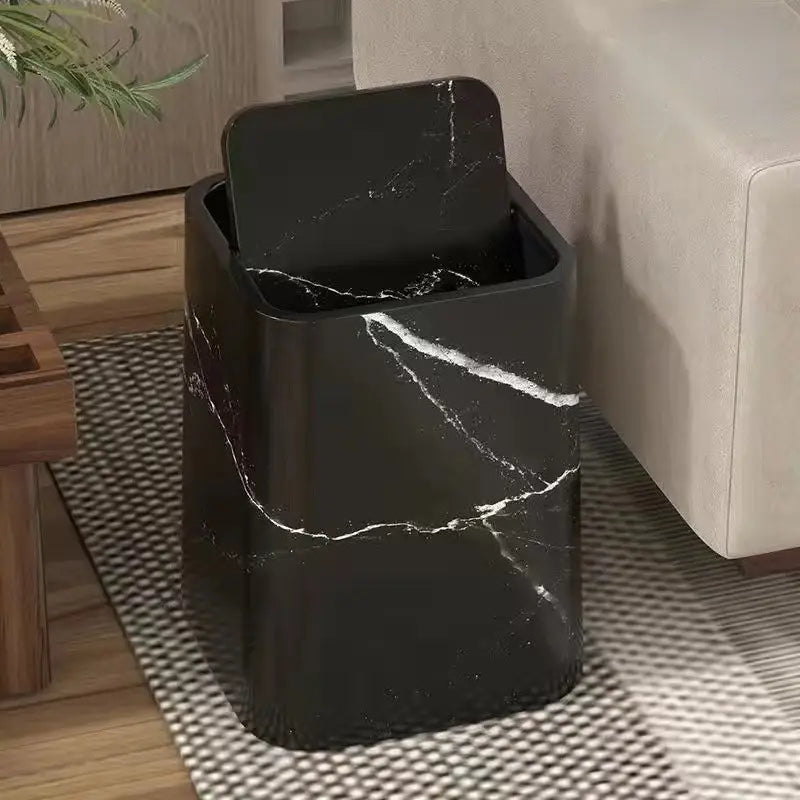 Black marble-patterned trash can in a room with a couch and rug.
