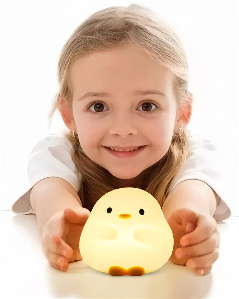 Child holding a chick-shaped night light with a white background