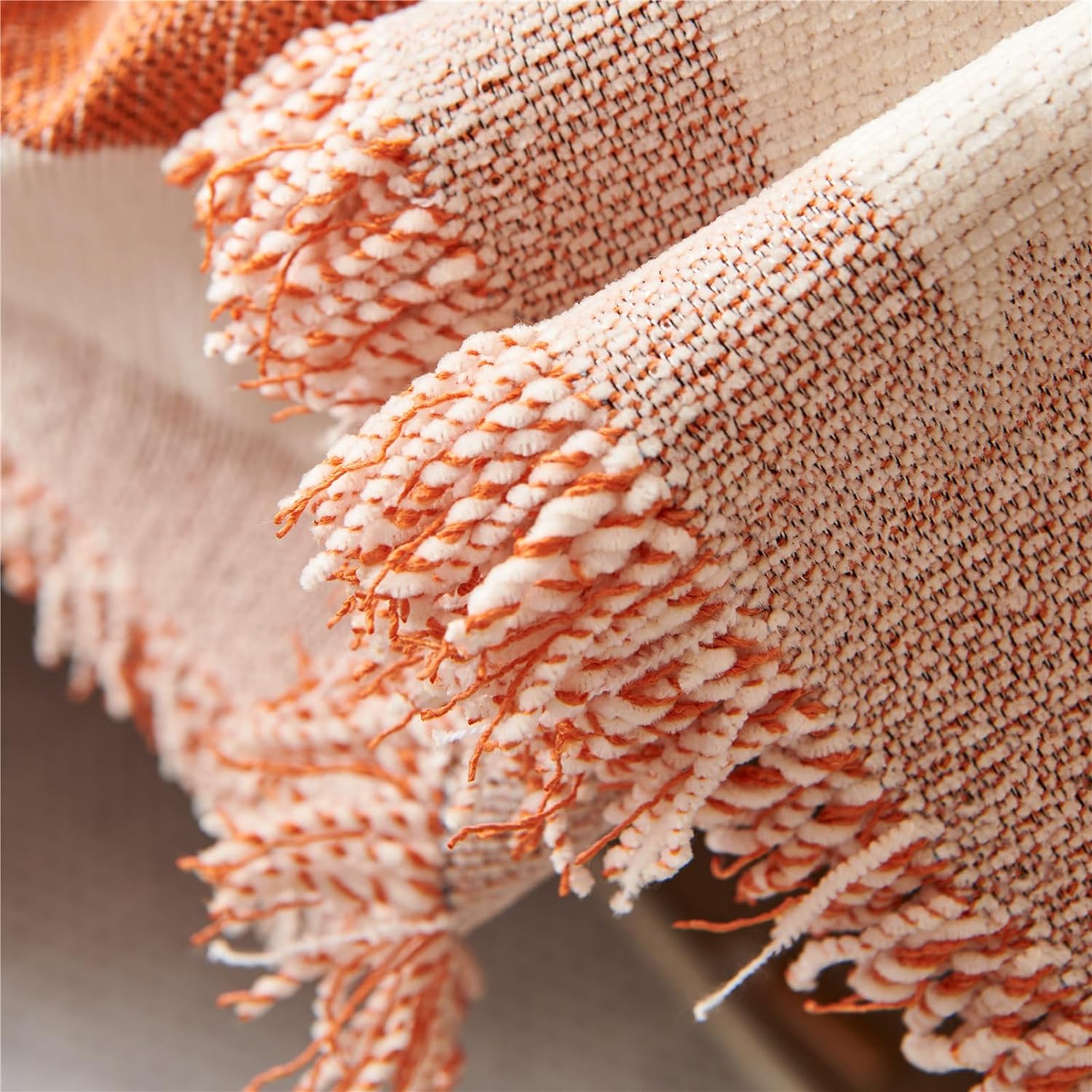 Close-up of a textured blanket with orange and beige colors.