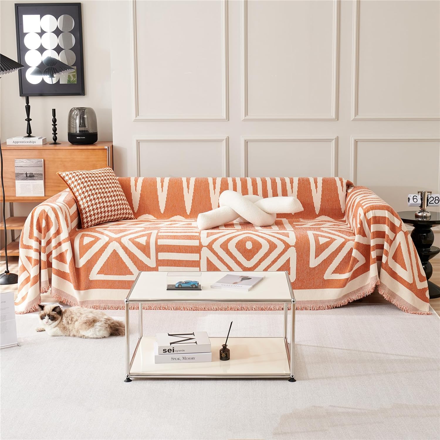 Living room with a patterned orange and white sofa, coffee table, and decor items.