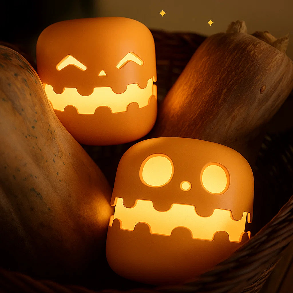 Two lit pumpkin lanterns with carved faces on a dark background