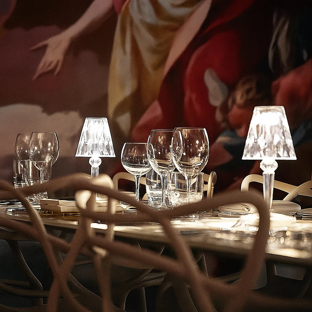Dining table with wine glasses and lamps in a dimly lit room