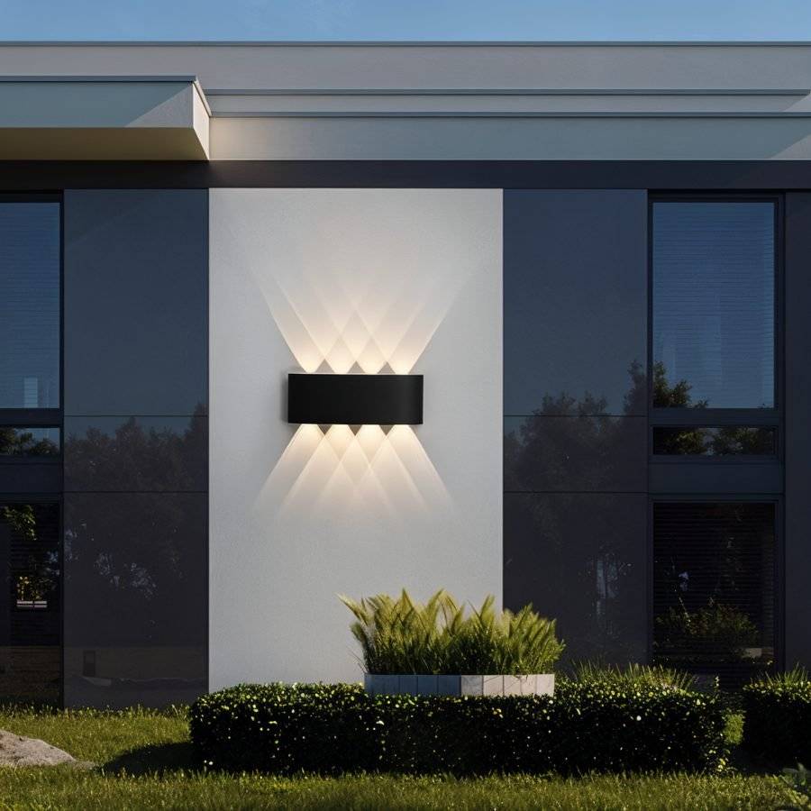 Modern outdoor wall light fixture on a building exterior with greenery.