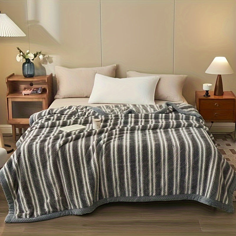 Bedroom with a bed covered in a striped blanket, nightstands, and lamps.