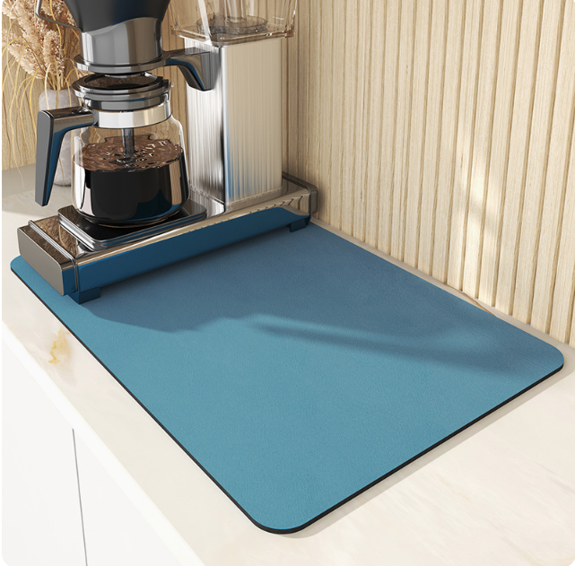 Blue mat in front of a coffee maker on a light-colored surface.