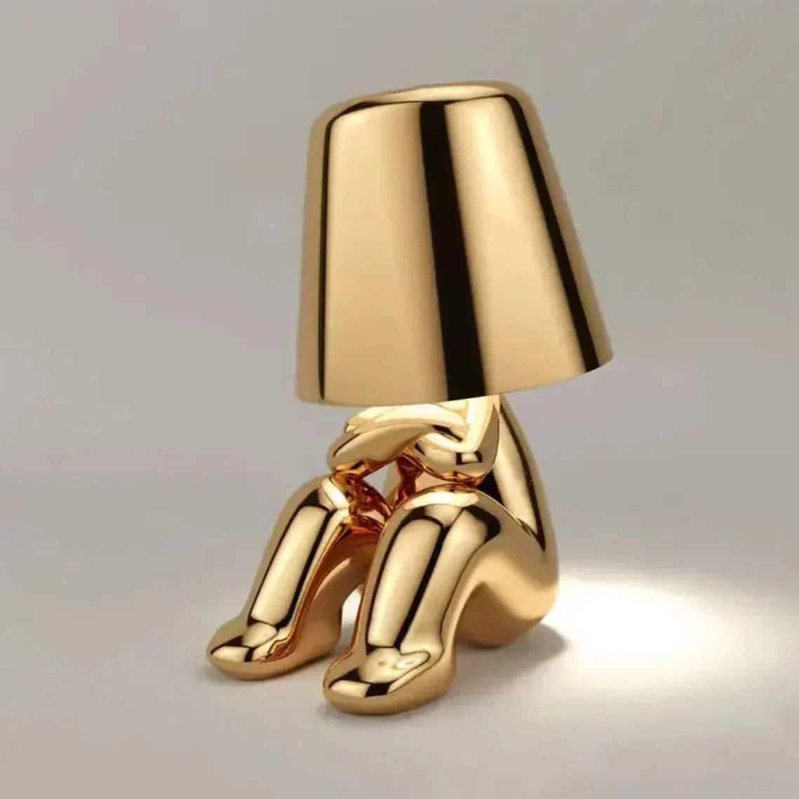 Gold table lamp with a unique design on a gray background