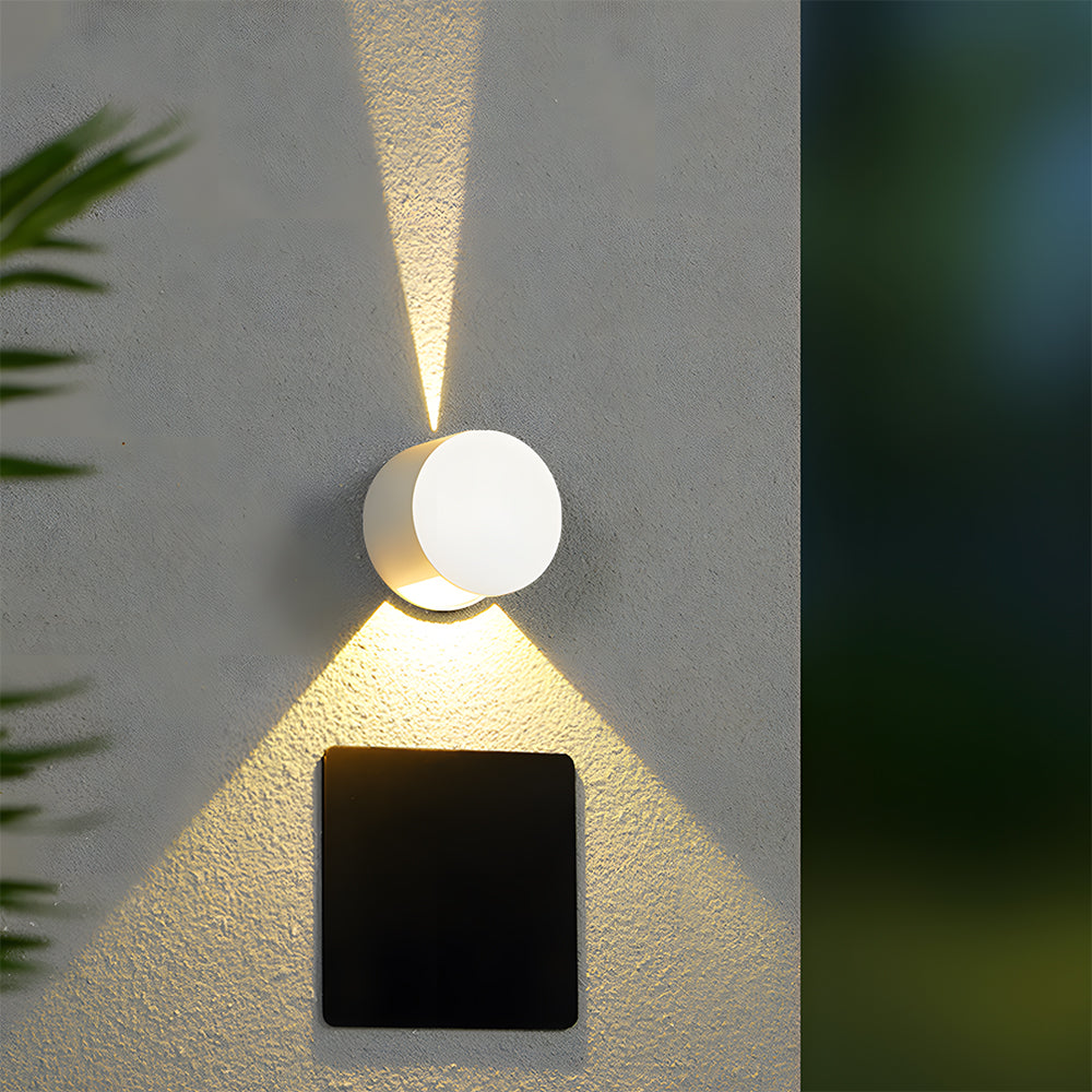 Modern outdoor wall light fixture on a textured wall with a blurred natural background