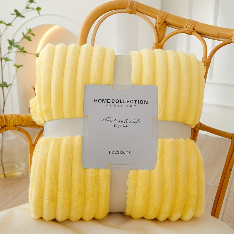 Yellow textured throw blanket with a label on a wicker chair.