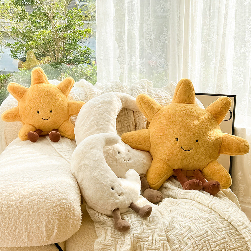 Two plush star toys on a couch with a window in the background