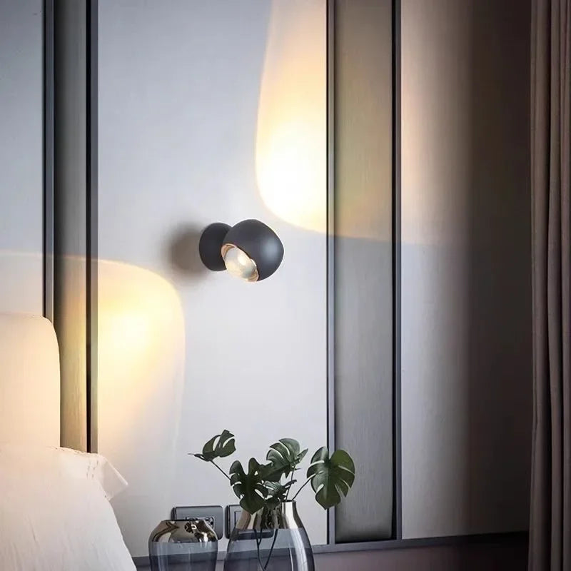 Modern wall sconce on a neutral wall with decorative elements.