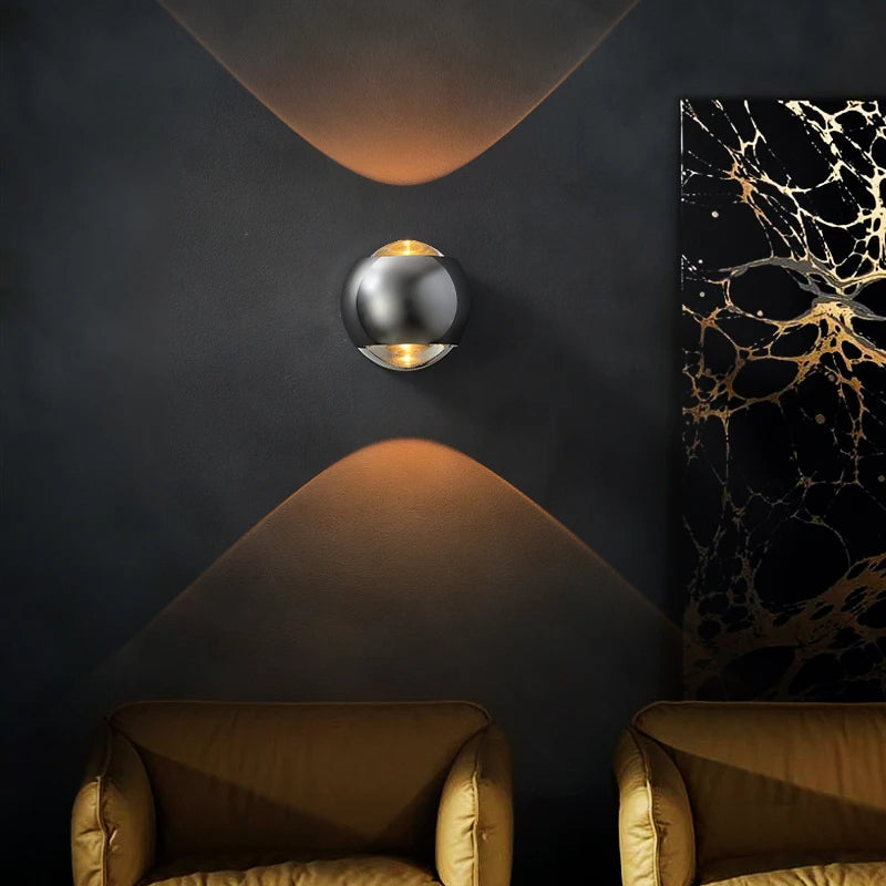 Modern wall sconce on a dark wall with two armchairs and a decorative painting.