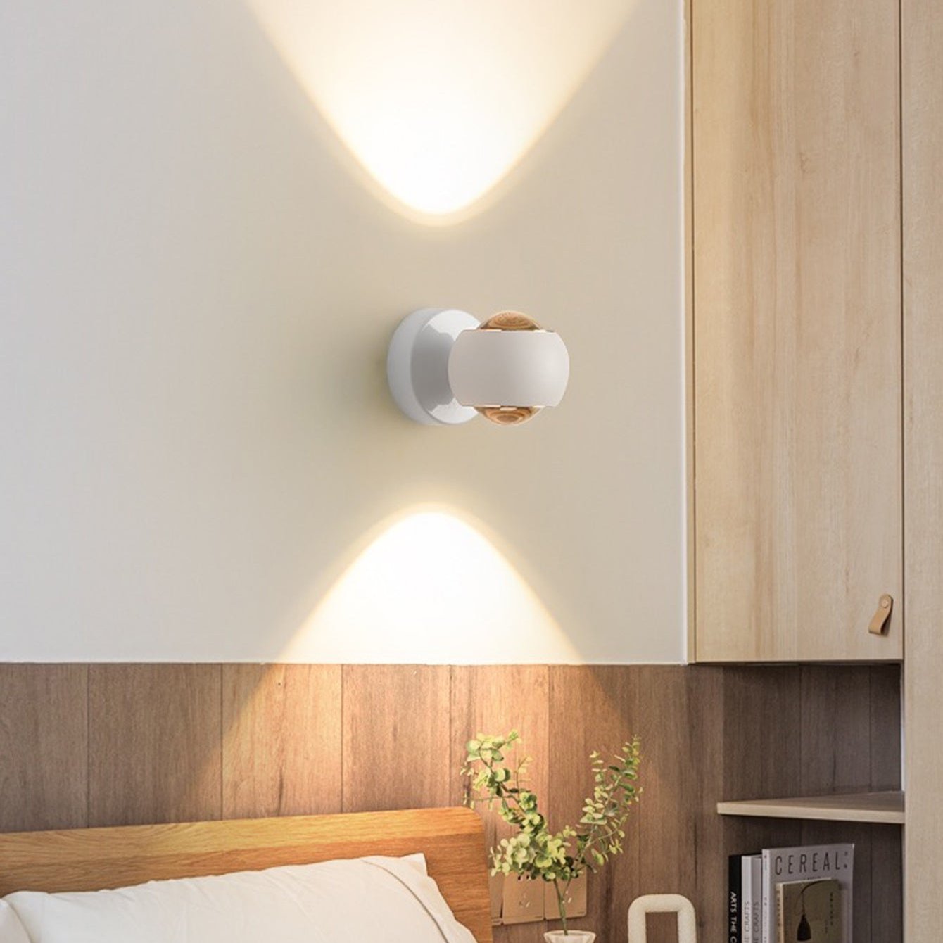 Modern wall light fixture on a neutral wall with wooden headboard and shelf.