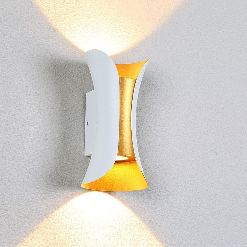 Modern wall light fixture with gold and white design on a gray wall.
