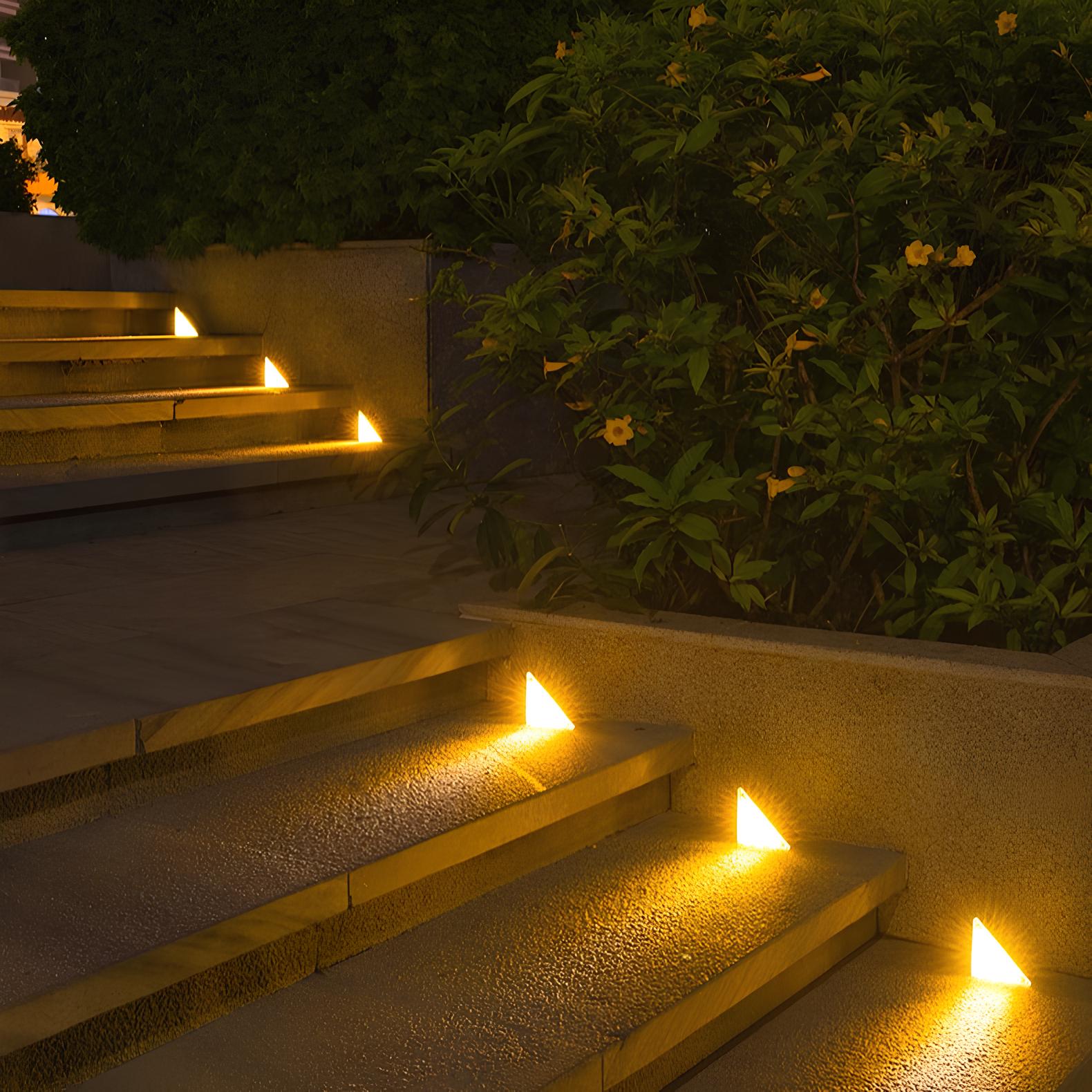 Outdoor steps illuminated by small lights with plants in the background