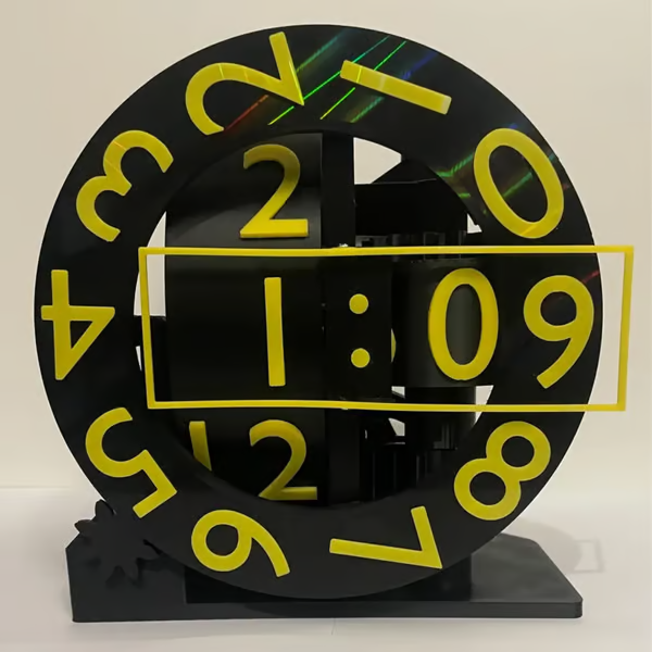 Black clock with yellow numbers and hands on a white background