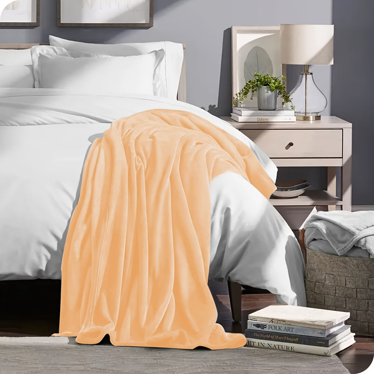 Orange blanket draped over a bed in a bedroom setting with a nightstand and lamp.
