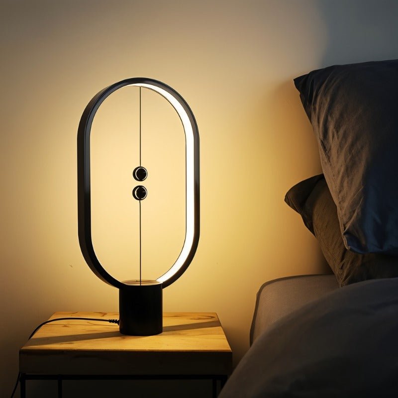 Modern table lamp on a bedside table with a warm glow in a bedroom setting.