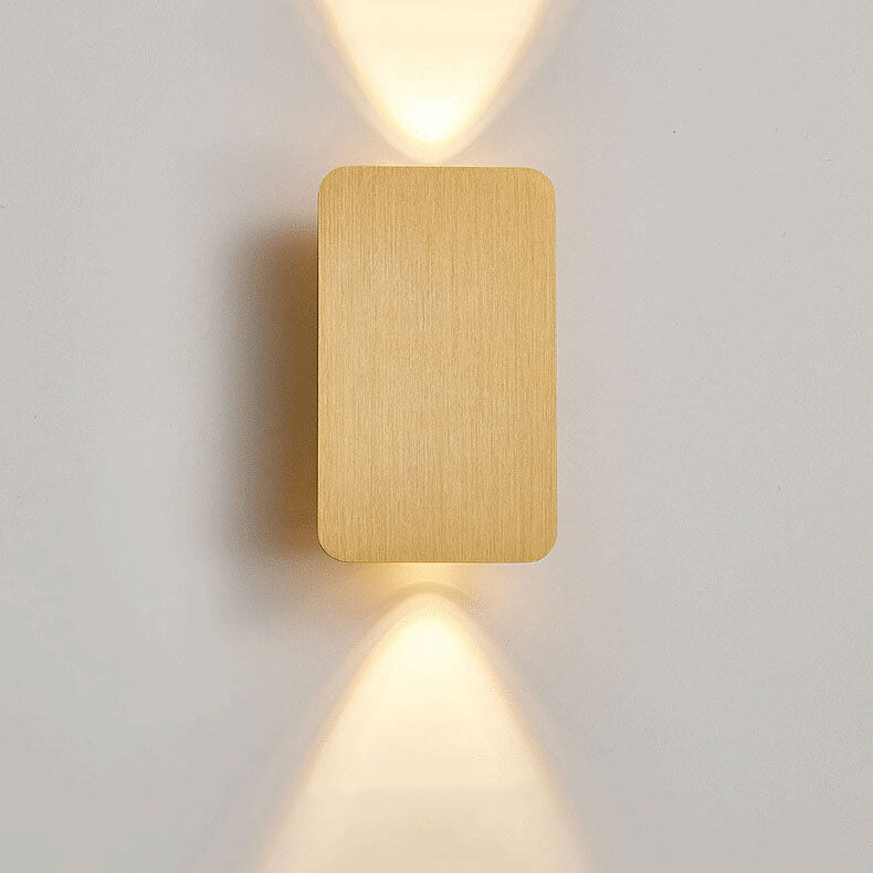 Gold square wall light fixture on a white wall