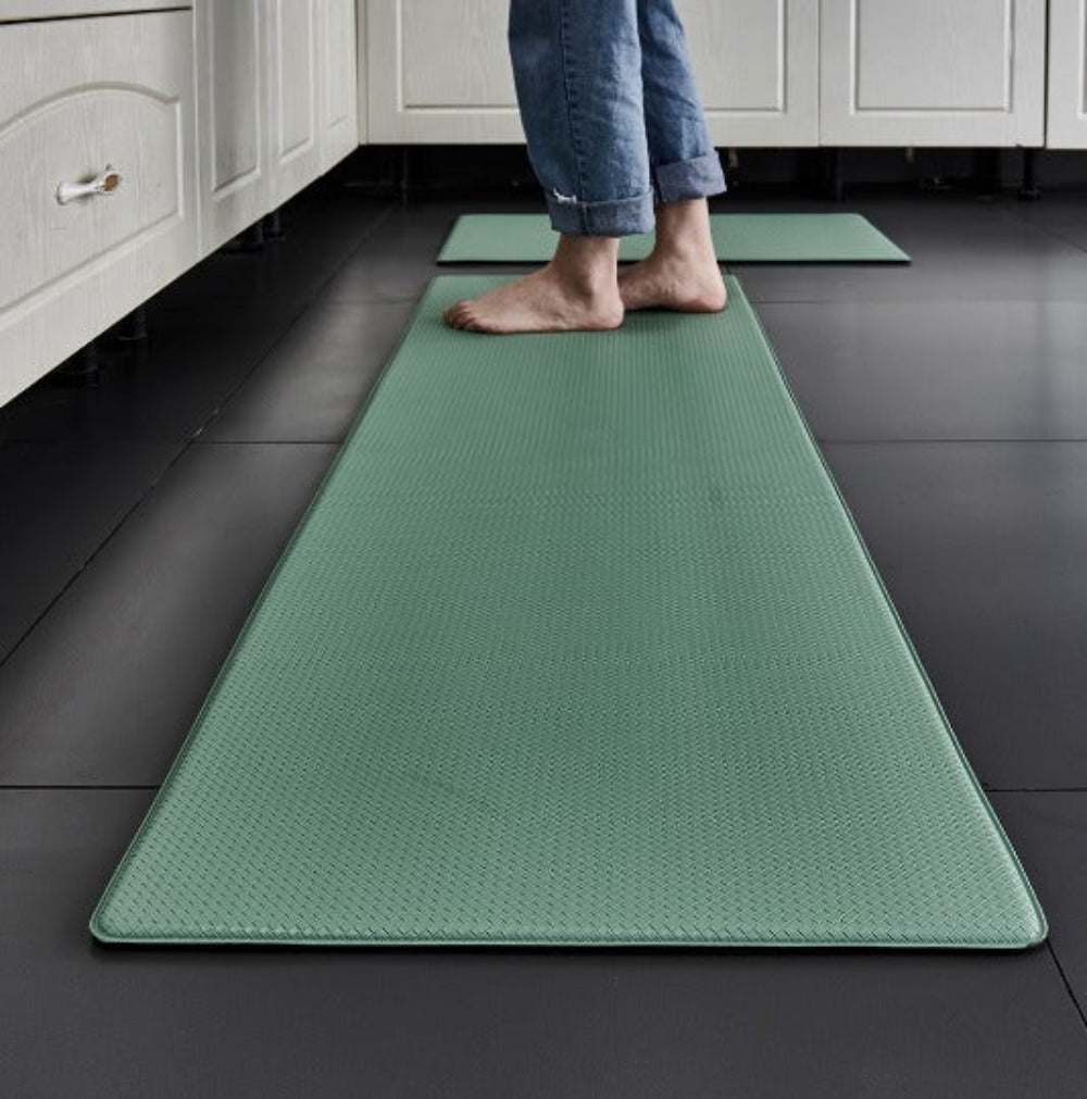 Person standing on a green kitchen mat in a kitchen setting