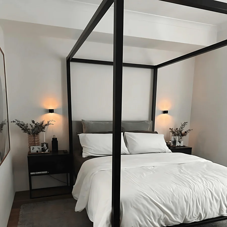 Modern bedroom with a canopy bed, nightstands, and wall lights.