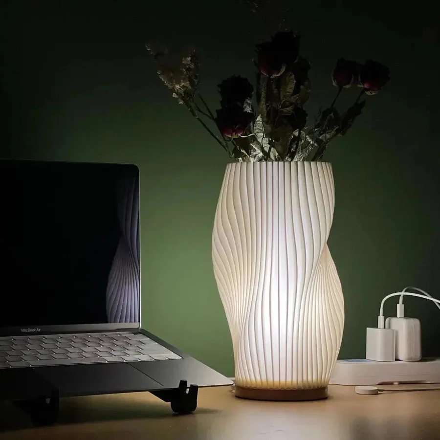 Lamp with ribbed design on a desk next to a laptop
