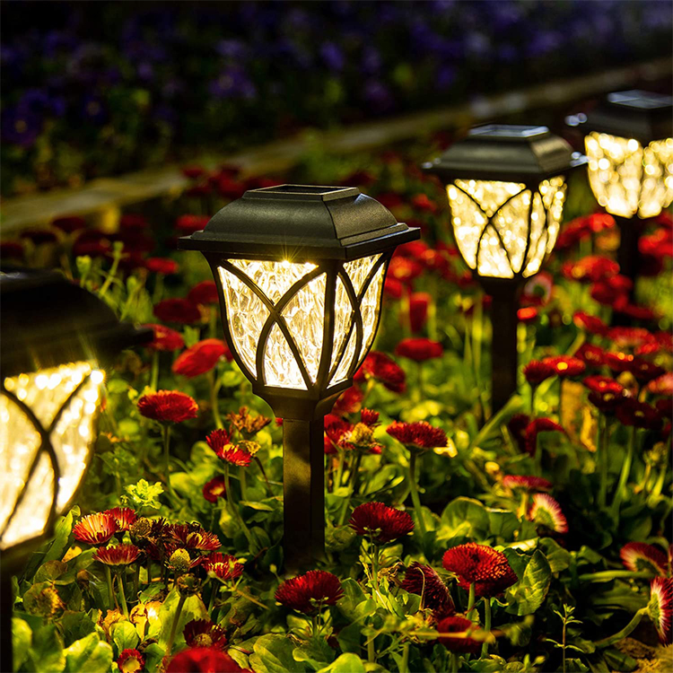 Solar garden lights illuminating a garden with flowers at night