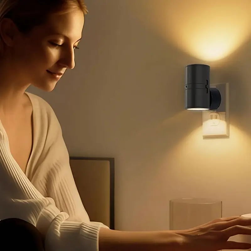 Woman sitting in a dimly lit room with a wall-mounted light fixture.