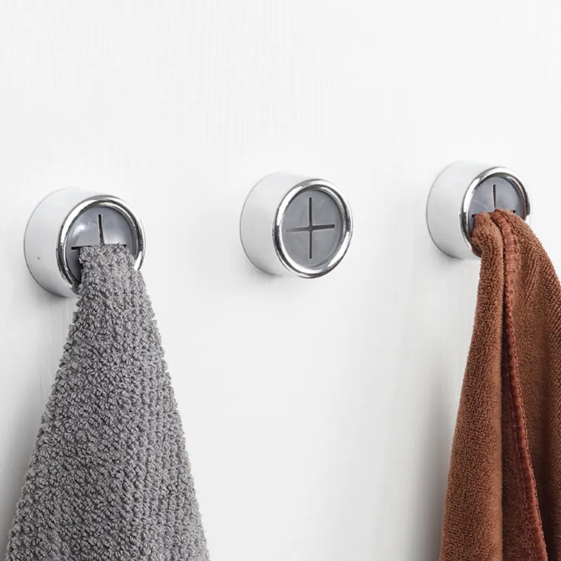 Three wall hooks with towels hanging on a white background