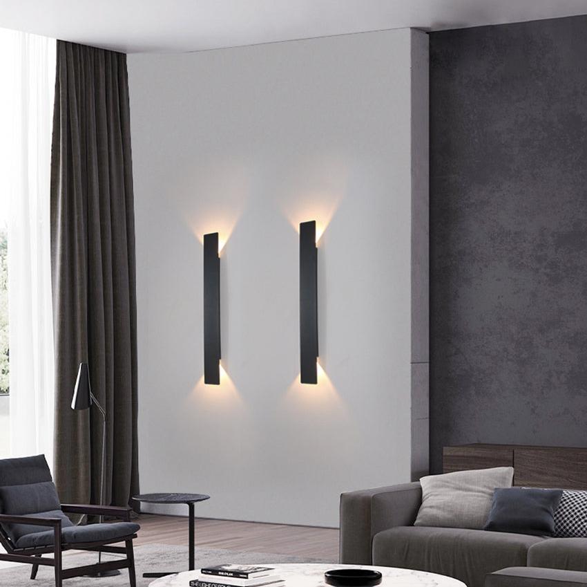 Modern living room with wall-mounted lamps and a gray sofa.
