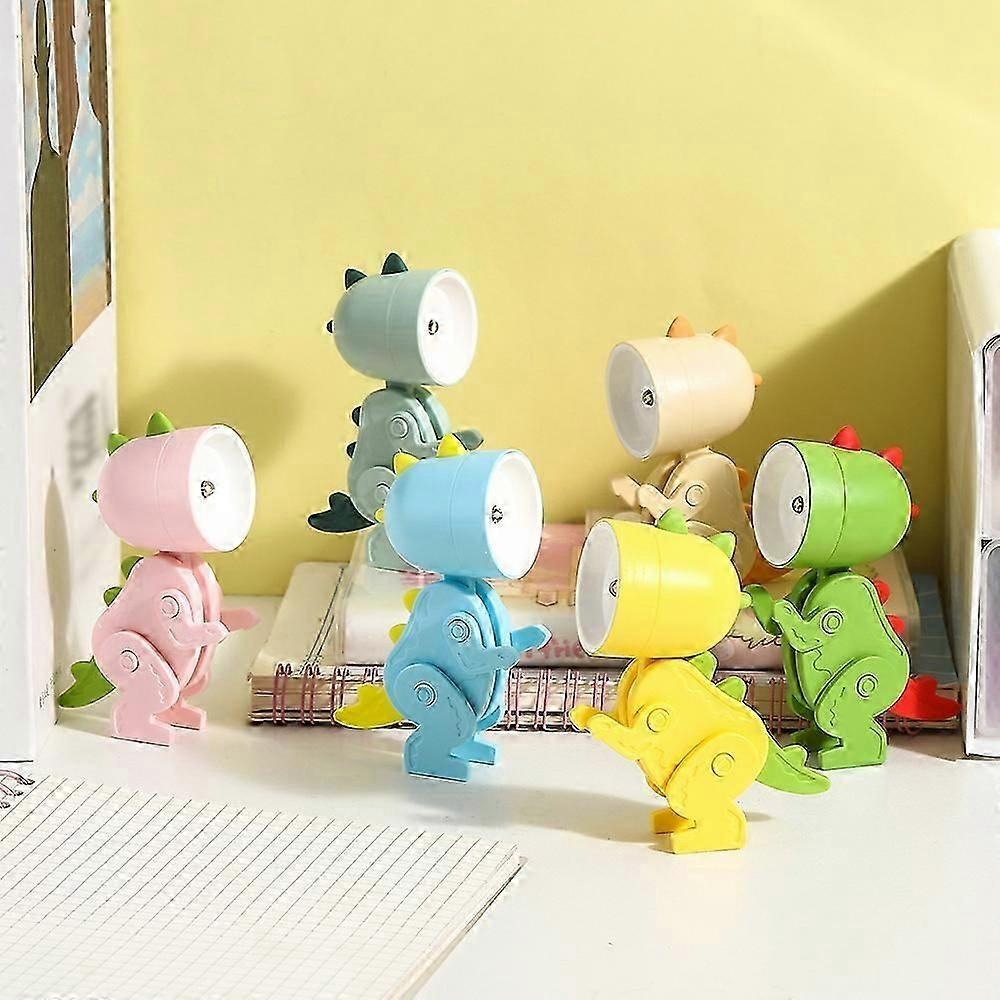 Colorful dinosaur-shaped night lights on a surface with a yellow wall in the background.