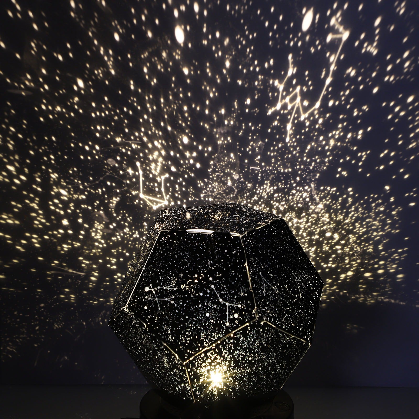 Star projector creating a night sky pattern on a dark wall