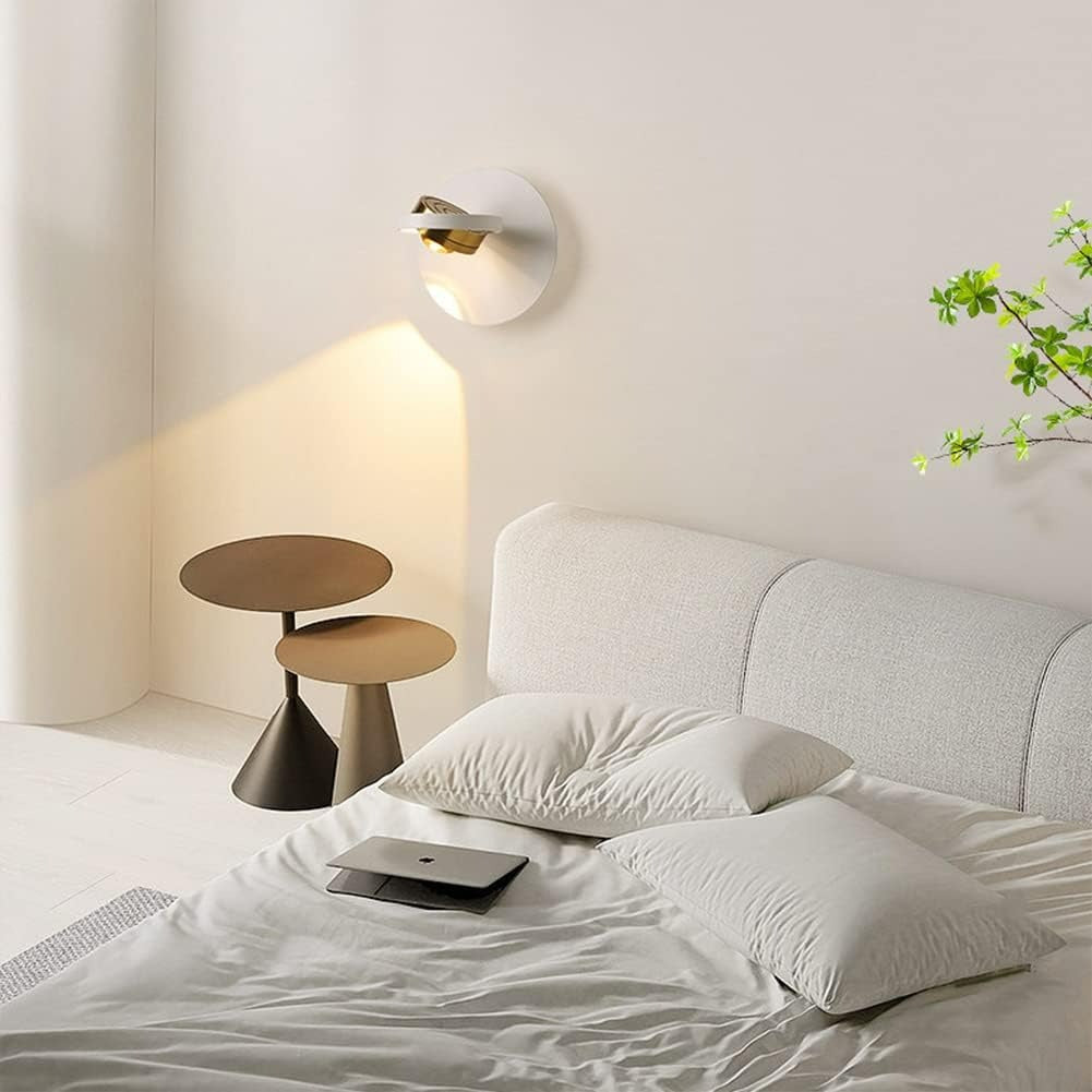 Modern bedroom with a bed, side table, and wall lamp.