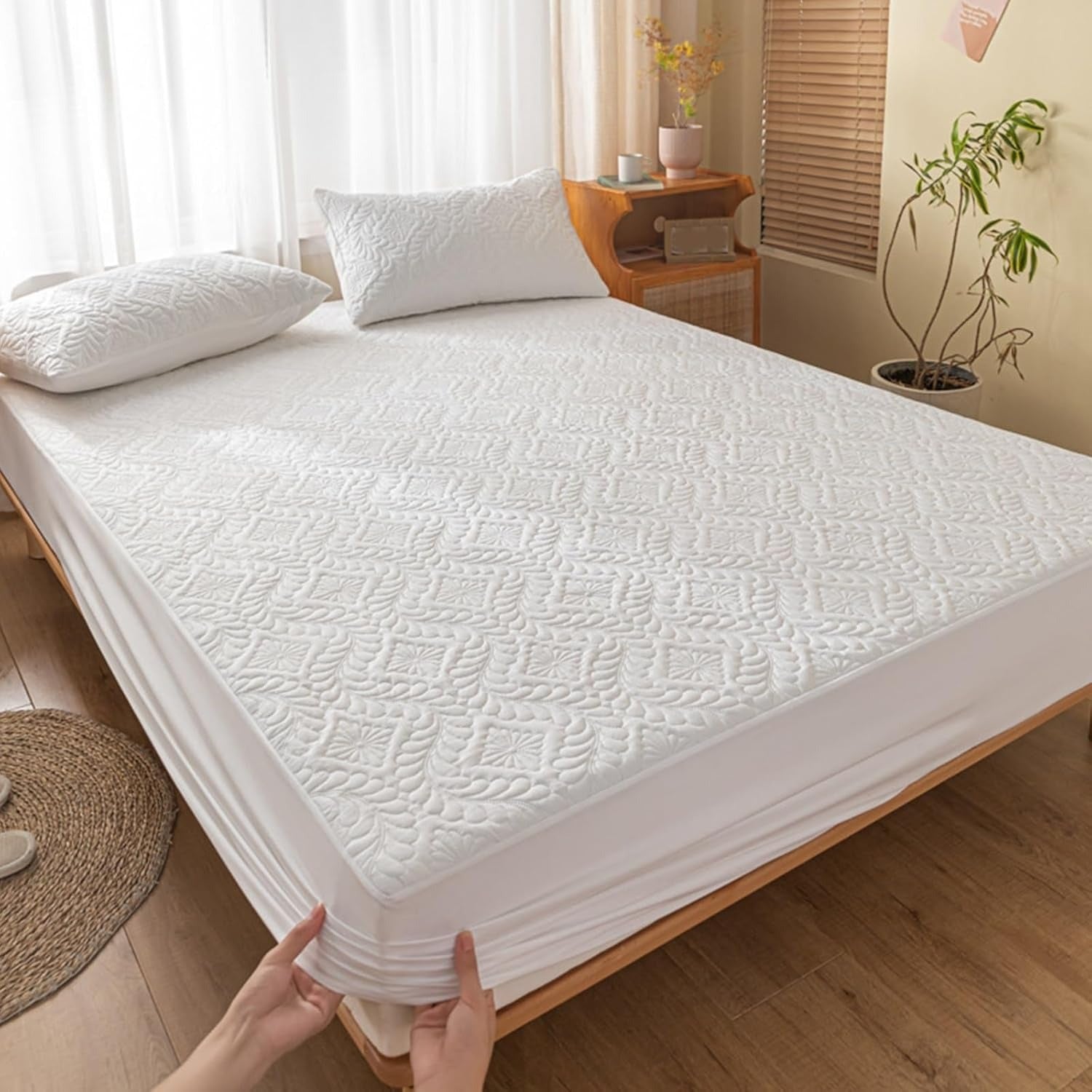White mattress cover being held by a person in a bedroom setting.