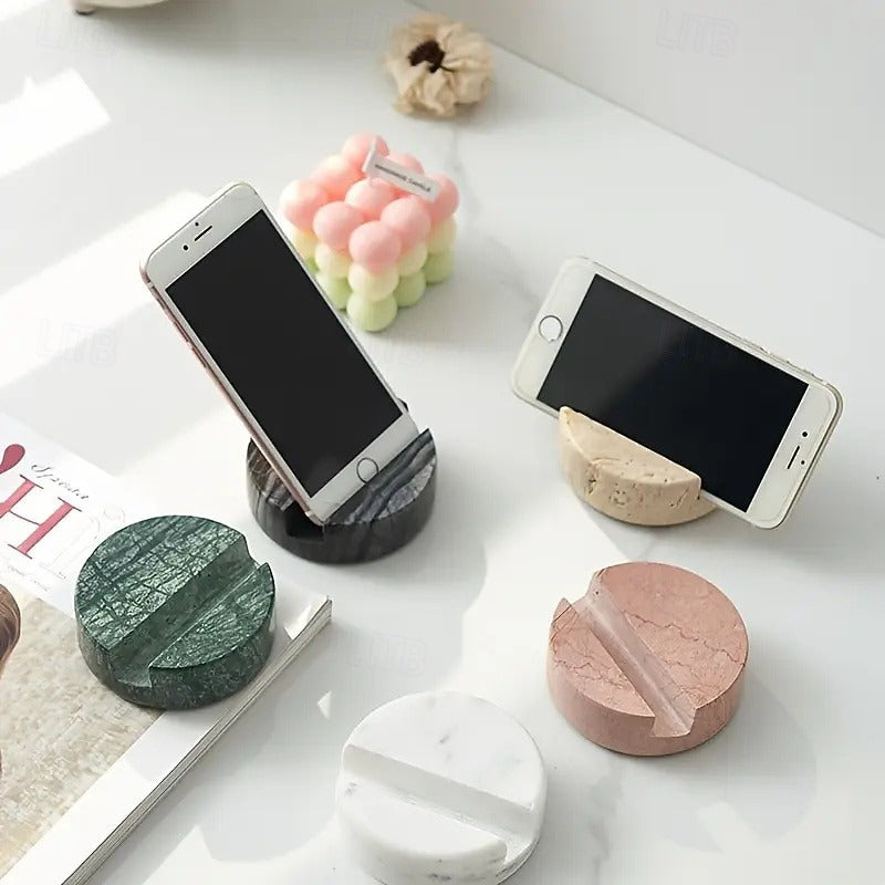Marble-textured phone stands on a white surface with phones on top