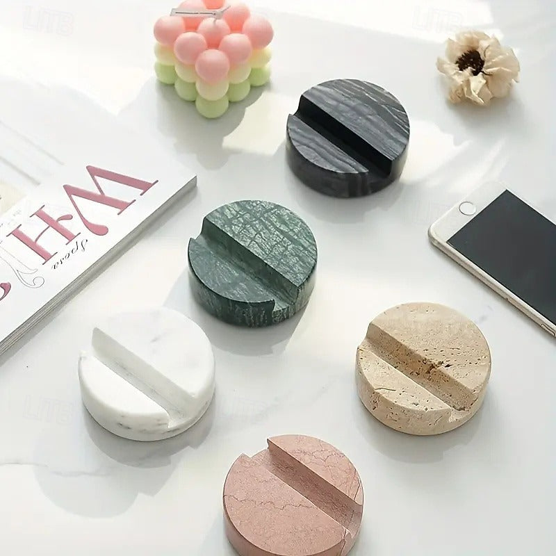 Set of marble-textured coasters on a white surface with a phone and magazine in the background.