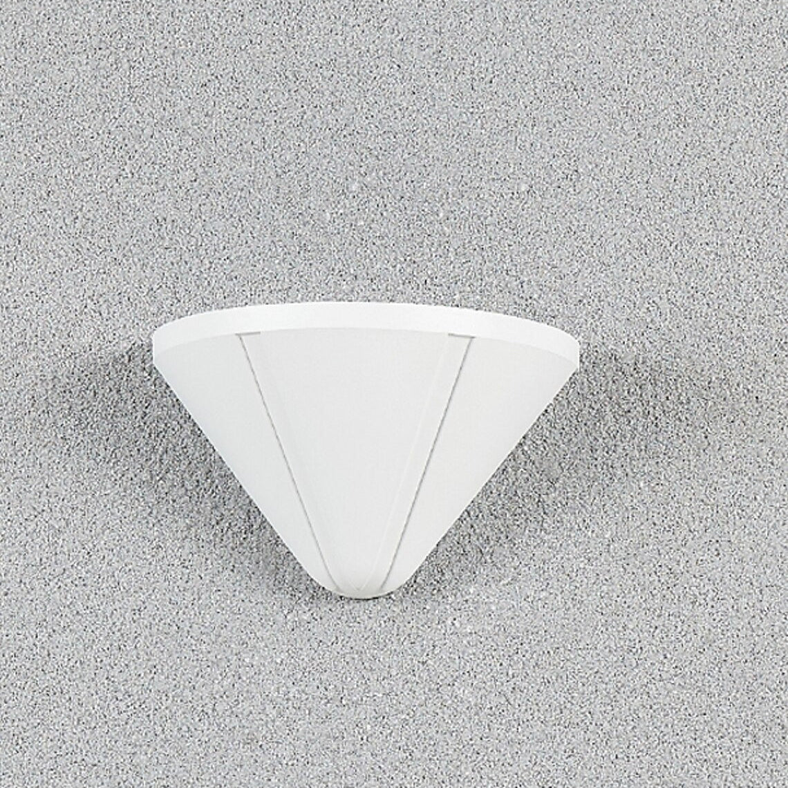 White triangular wall light fixture on a gray concrete wall