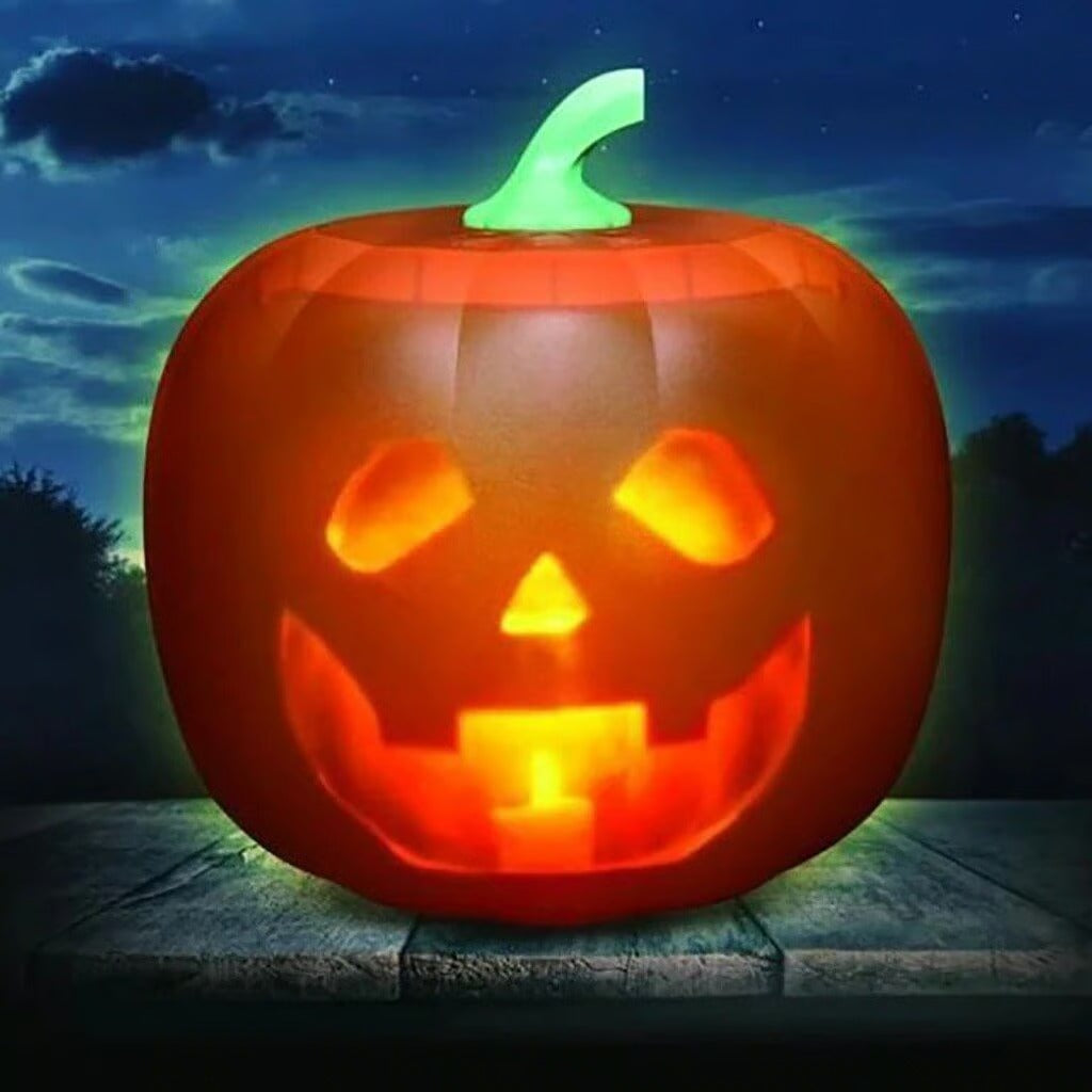 Inflatable pumpkin with glowing face on a wooden surface at night