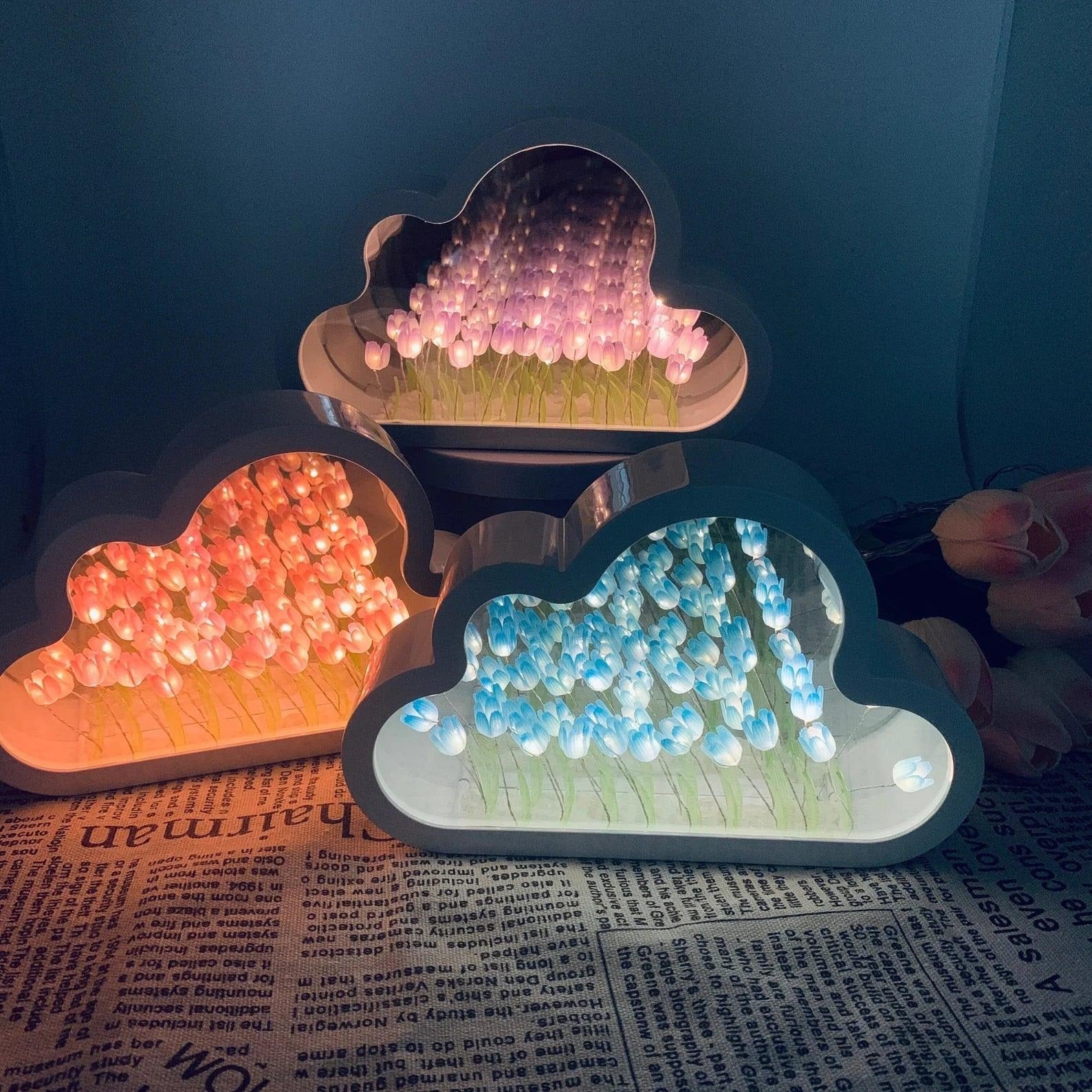 Three cloud-shaped LED lights with colorful beads on a newspaper background