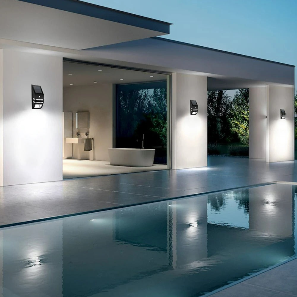 Modern house exterior with a pool area and illuminated interior.