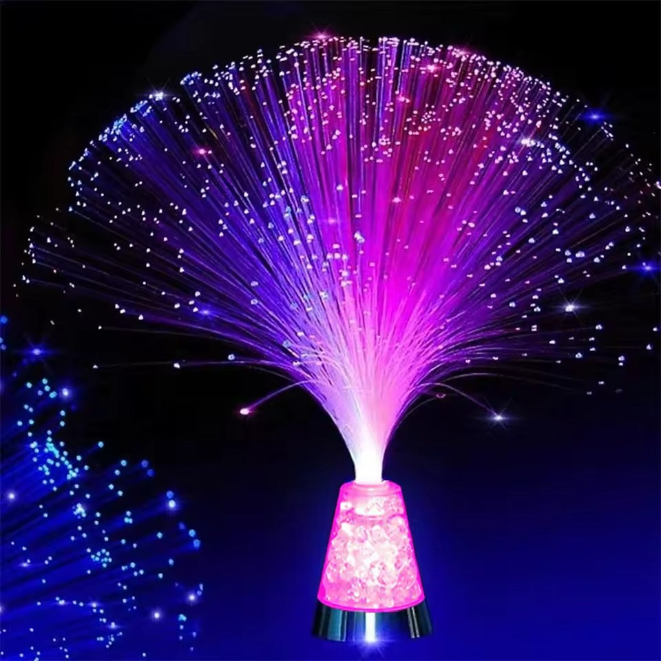 Fiber optic light with pink base and multicolored fibers on a dark background