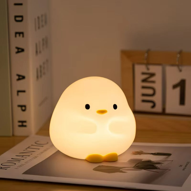 Cute chick-shaped night light on a magazine with a calendar in the background