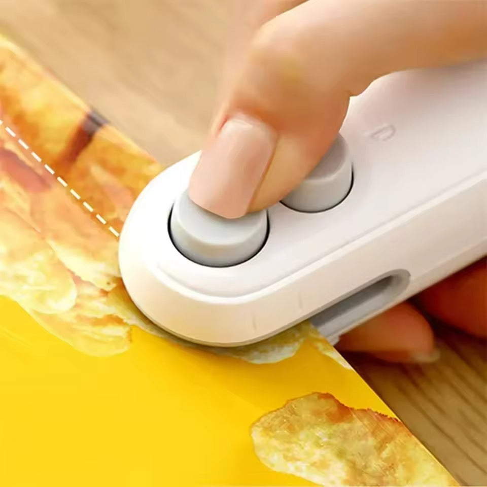 Hand using a small white device to cut a piece of yellow paper with a grid pattern.
