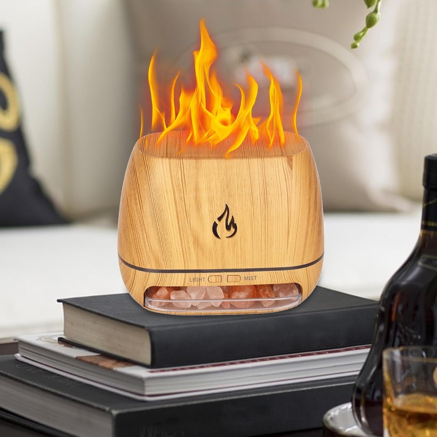 Wooden flame-shaped diffuser on a stack of books with a blurred background