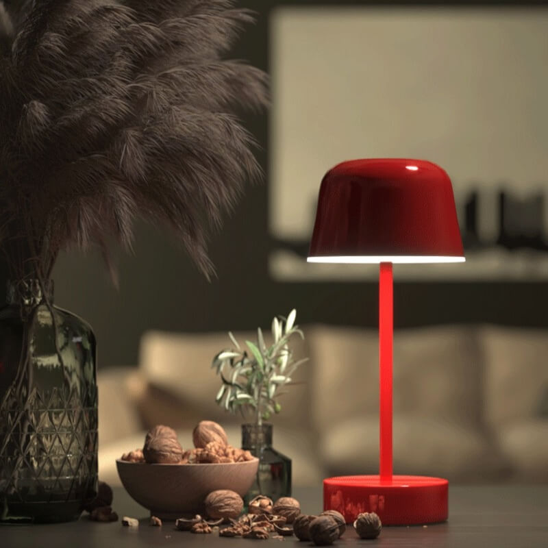 Red table lamp on a surface with decorative items in a blurred indoor setting