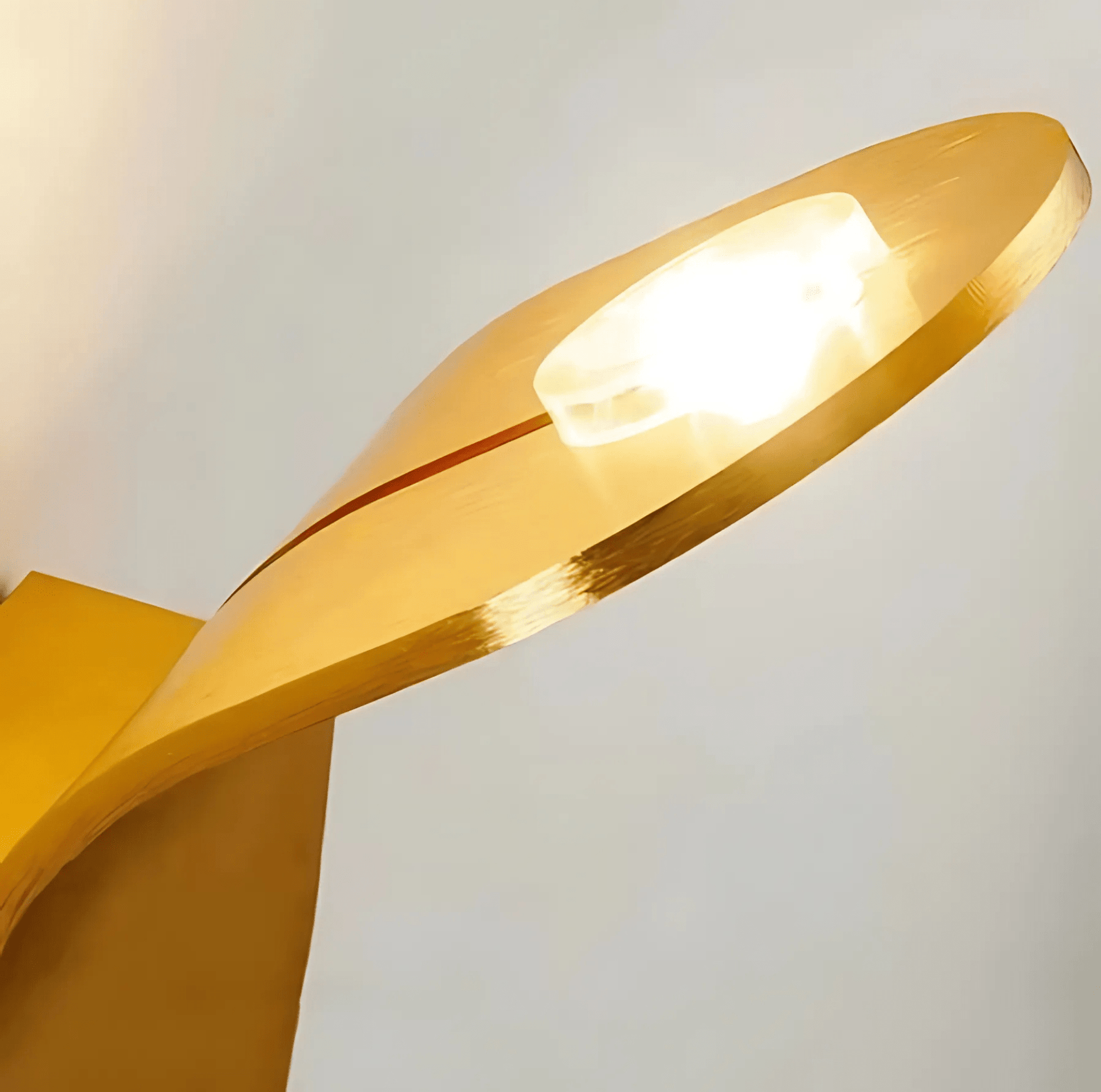 Gold lamp with a soft glow on a light gray background