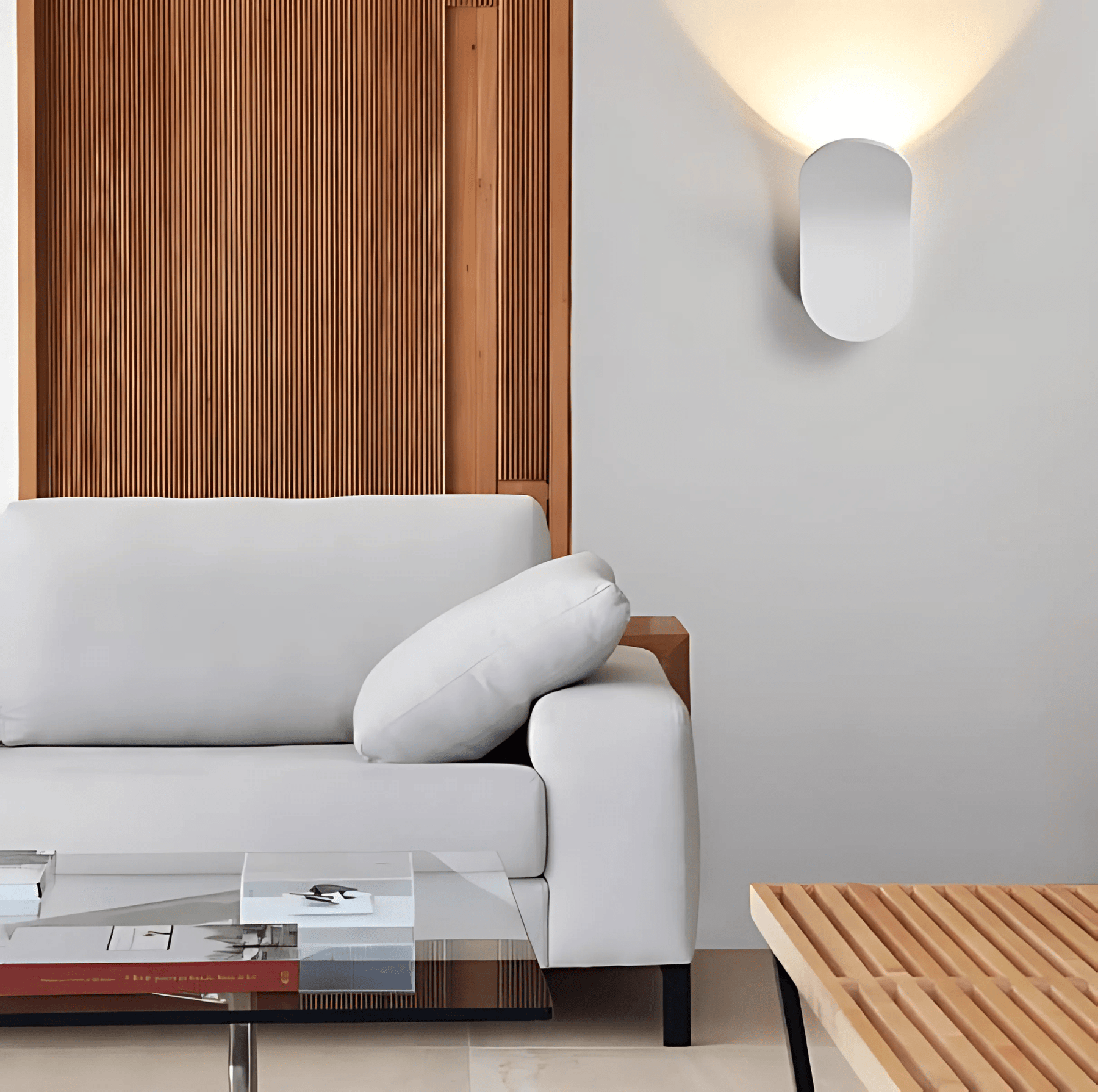 Modern living room with a gray sofa, wooden coffee table, and wall-mounted light fixture.